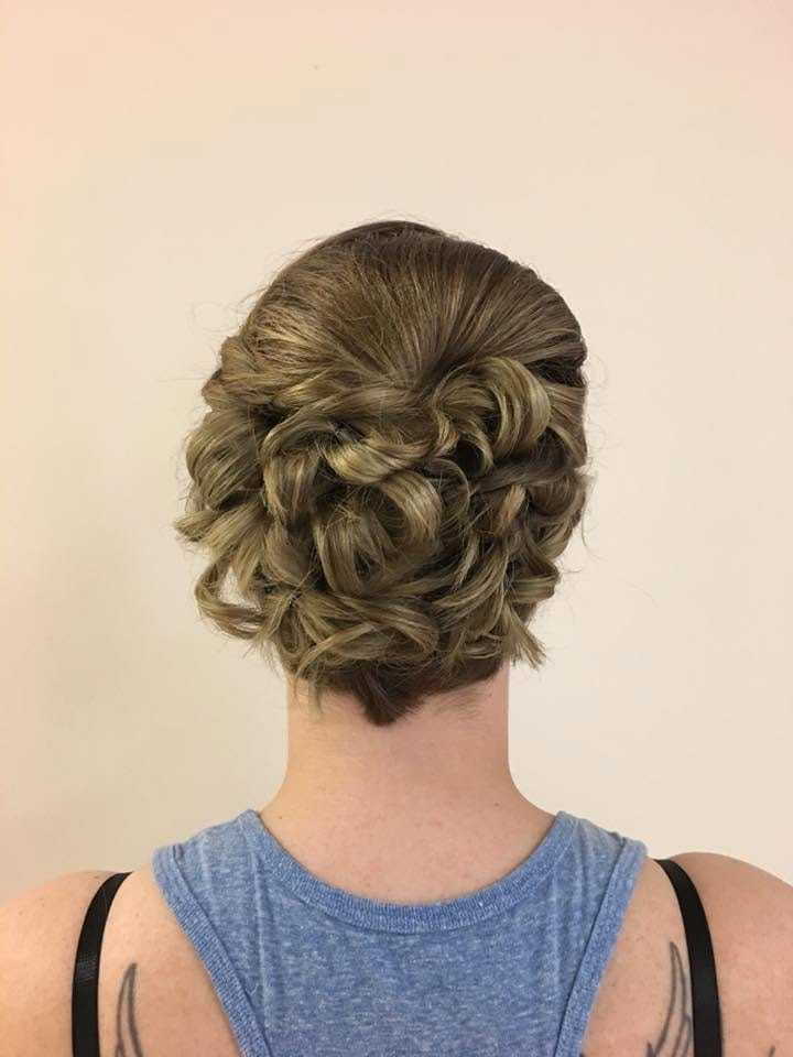 Intricate braided updo hairstyle on a person with light brown hair, wearing a blue tank top.