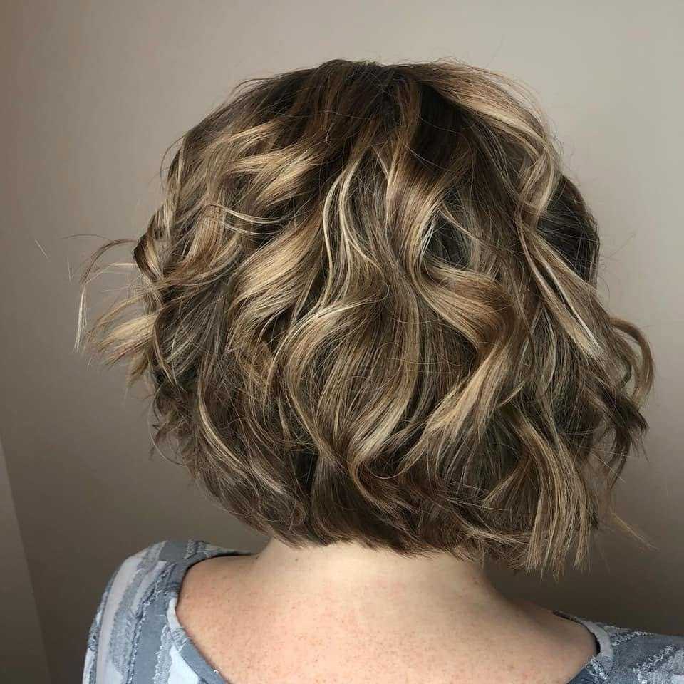 Short, wavy, light brown hairstyle viewed from the back.