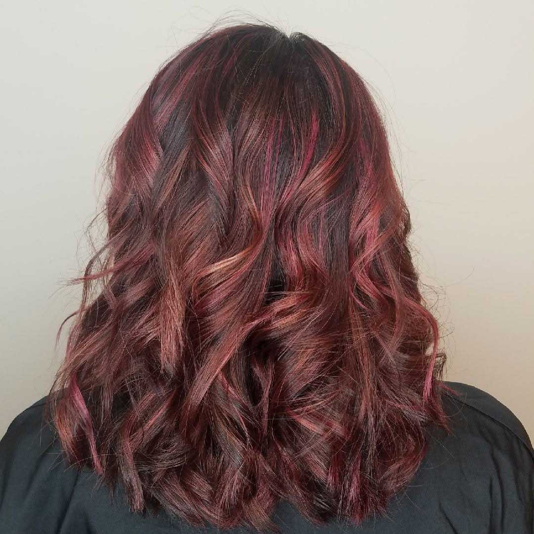 Curly hair in shades of red and brown from behind.