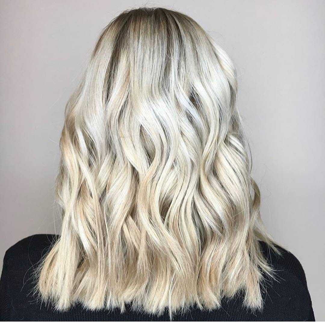 Blonde wavy hair styled in a shoulder-length cut, viewed from the back.