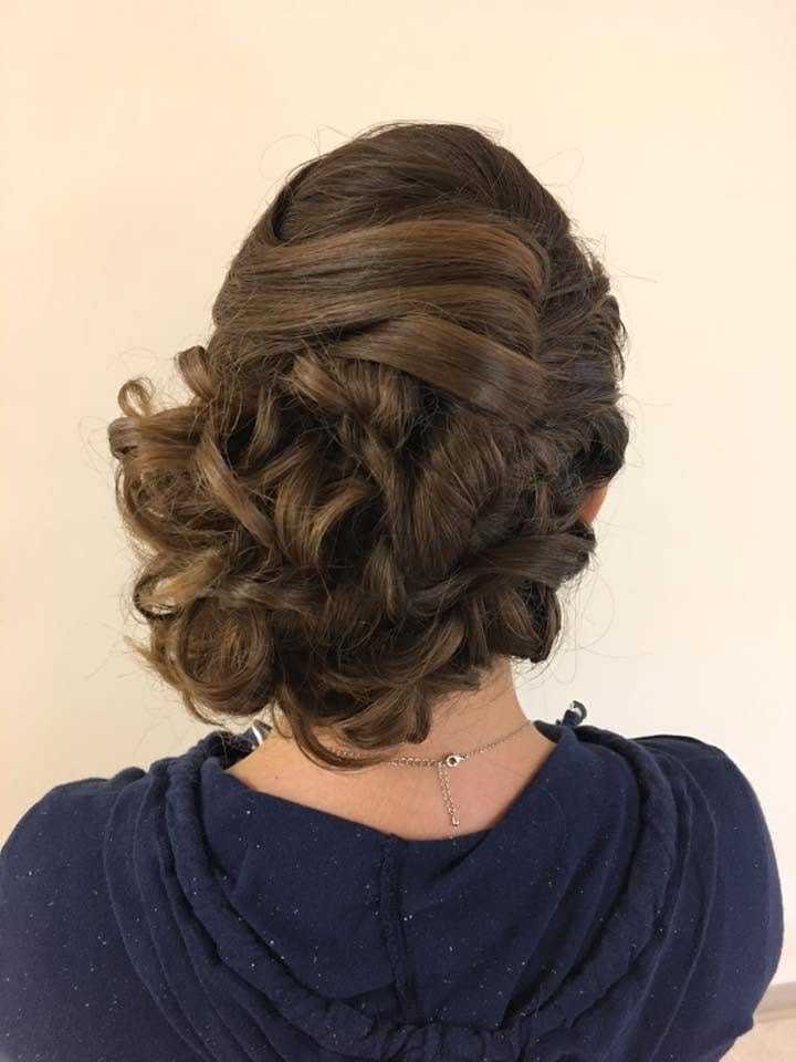 Elegant updo hairstyle with intricate curls viewed from the back.