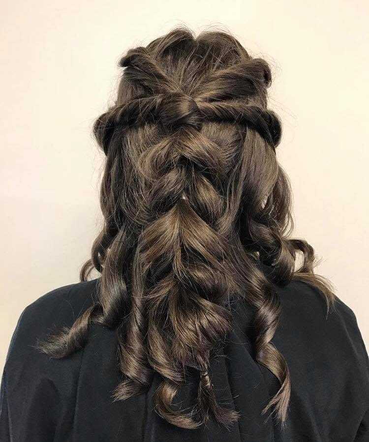 Braided hairstyle with loose curls and twists, viewed from the back.