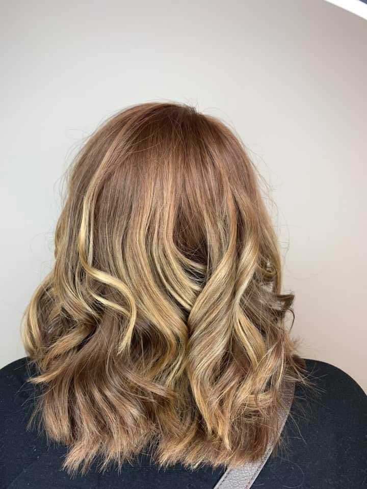 Brown hair with blonde highlights, styled in loose waves, back view.